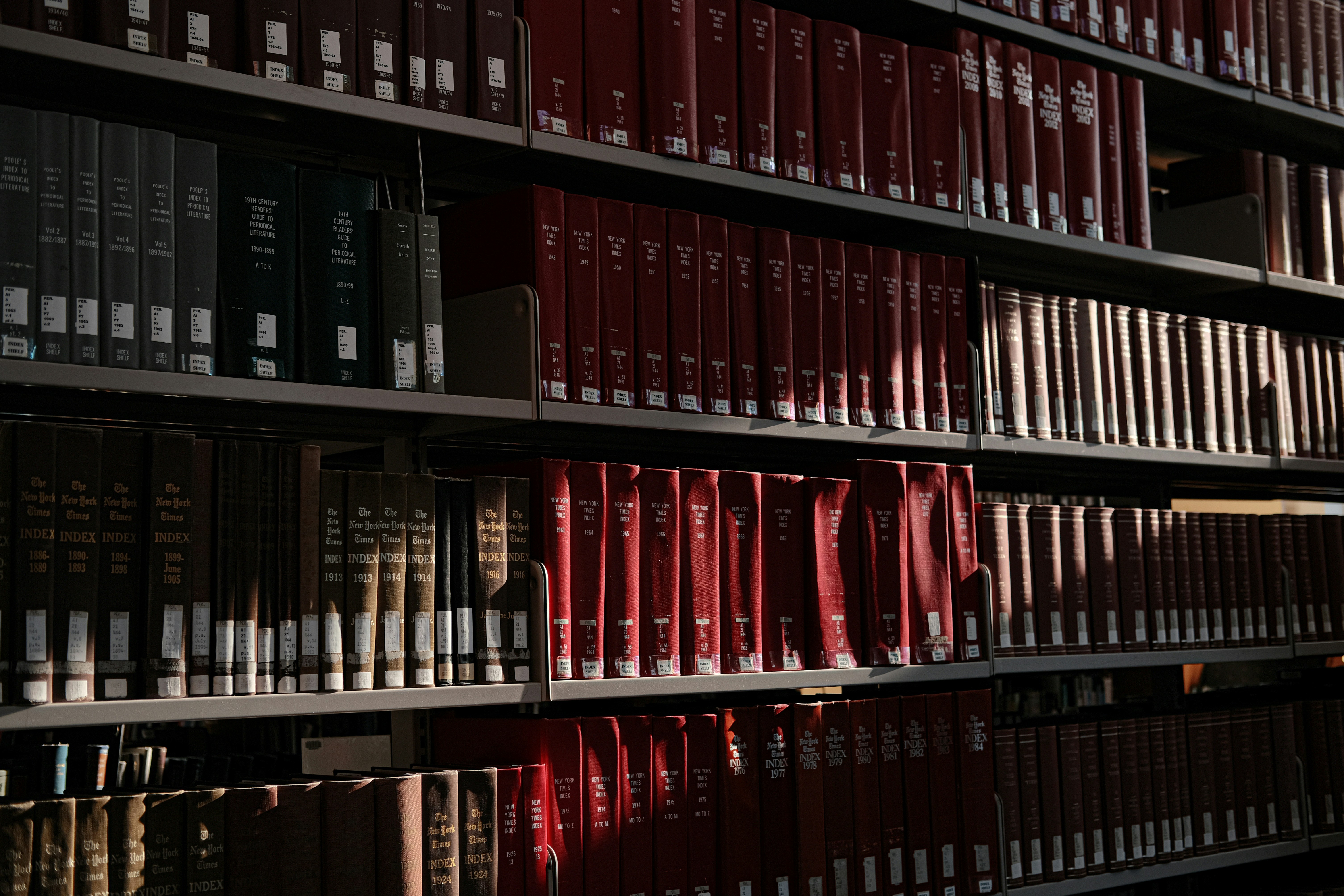 Books fill shelves in a well-lit library